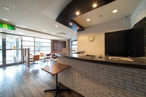 Un intérieur moderne avec un mur en briques, un comptoir noir et une horloge.