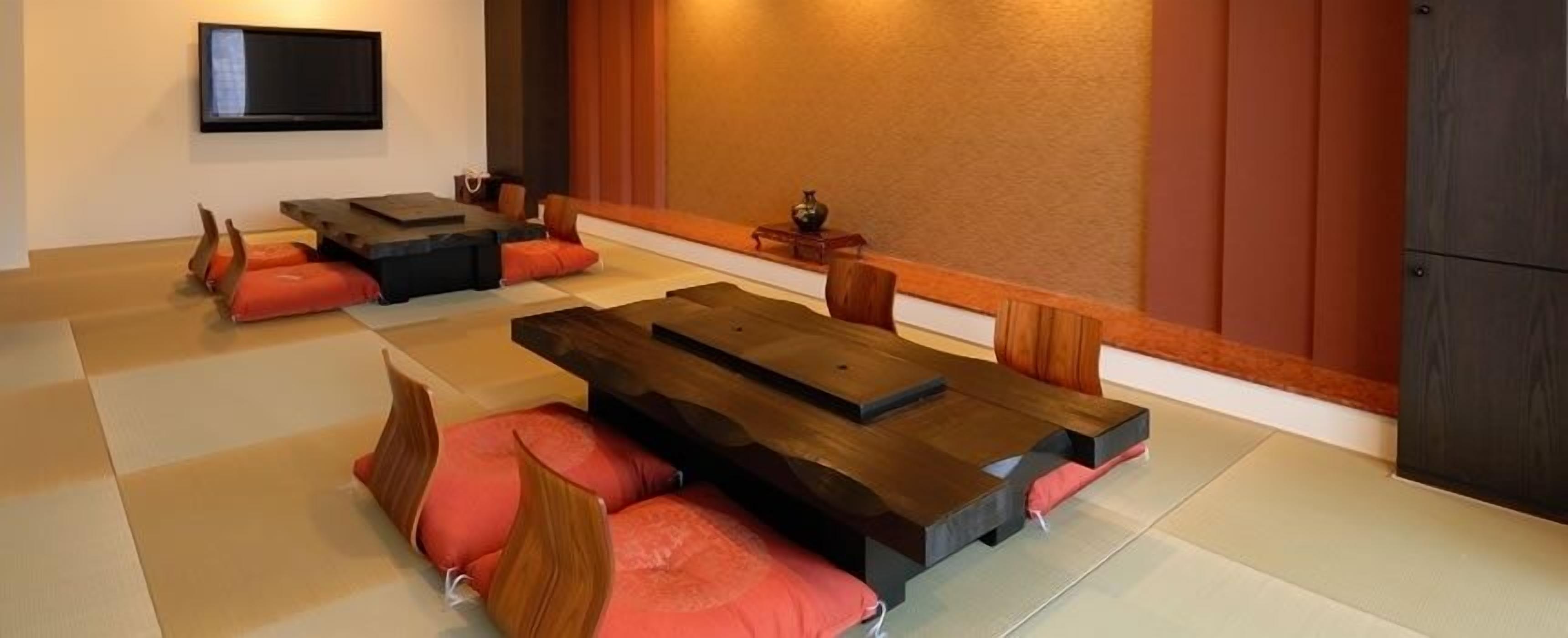 A tatami mat room with a low wooden table and cushions.