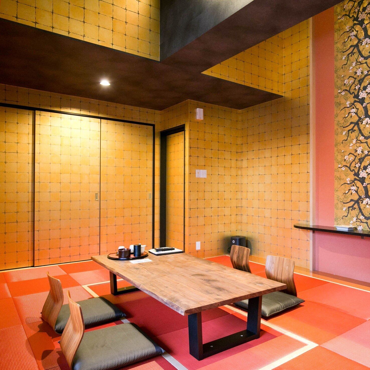 A traditional Japanese-style room with tatami flooring, a low table, and shoji screens.