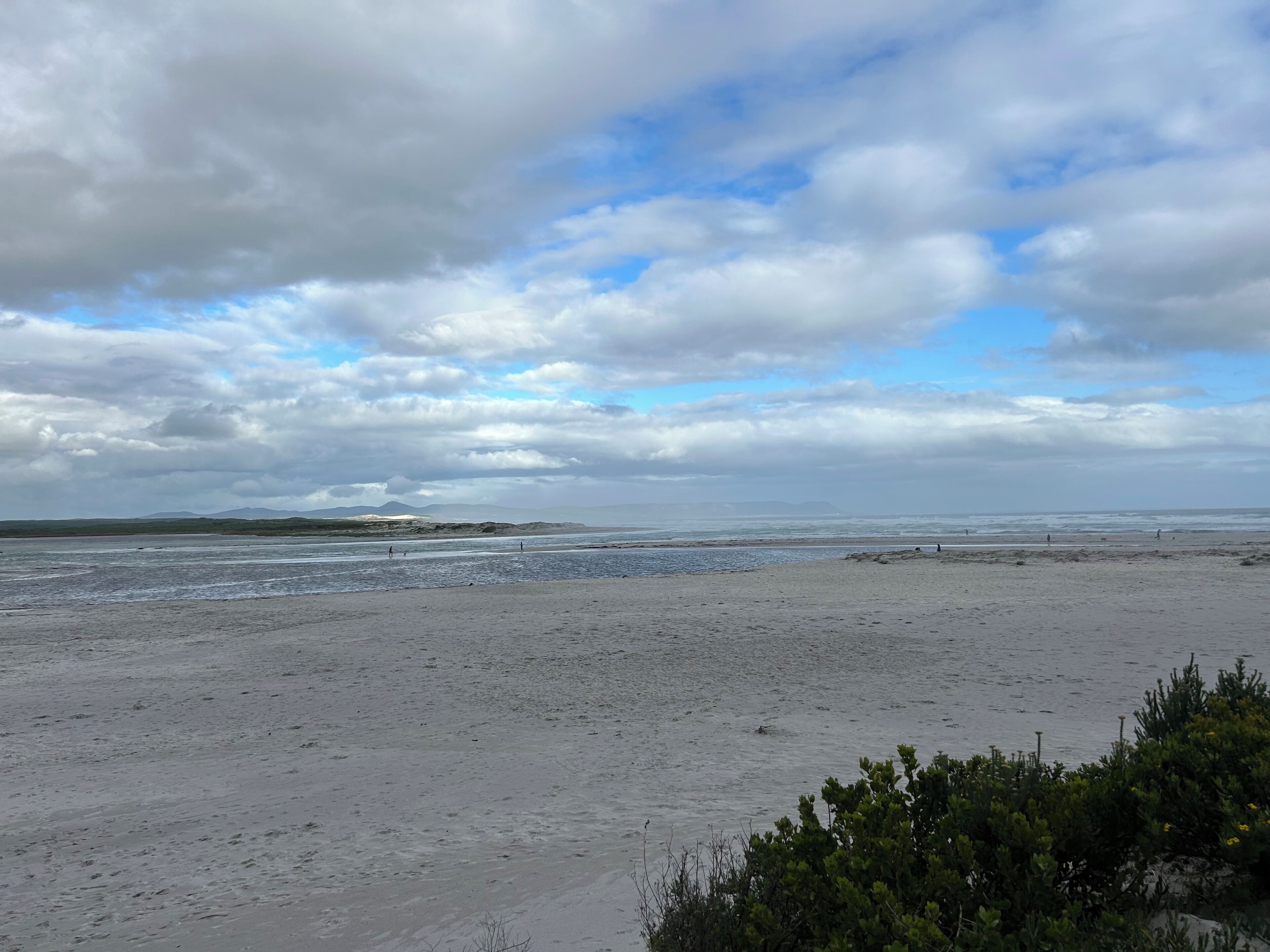 A beach with a wide sandy area and a view of the ocean.