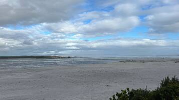 A beach with a wide sandy area and a view of the ocean.