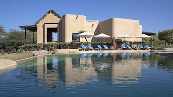 Alberca al aire libre, sombrillas en la alberca y camastros