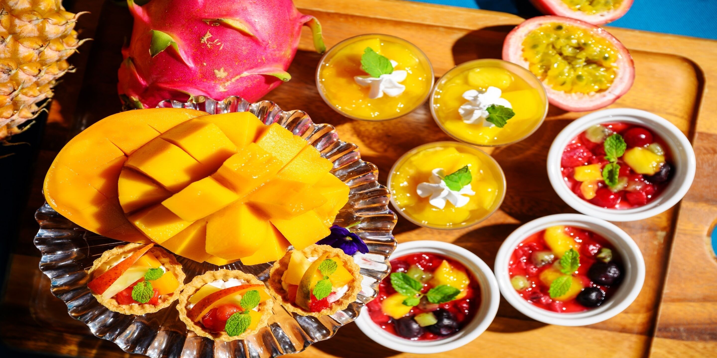 A variety of fruit-based desserts on a wooden tray.