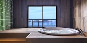 A spa area with a hot tub, wooden flooring, and a view of the sea through a glass door. - TWIN-LINE HOTEL YANBARU OKINAWA JAPAN (Nago)