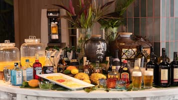 Eine Bar mit verschiedenen Alkoholflaschen, Gläsern und einer Obstplatte.