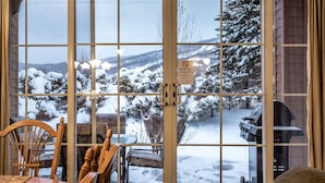 A dining area with a view of a snowy landscape through large windows.