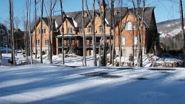 A large, multi-story building with a symmetrical facade, multiple windows, and a prominent entrance with steps.