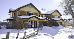 A large two-story house with a covered porch and a snow-covered roof. - L'Aiglon - RVMT (Mont-Tremblant)