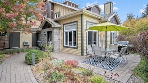 A house with a patio, outdoor seating, and a grill. - L'Aiglon - RVMT (Mont-Tremblant)