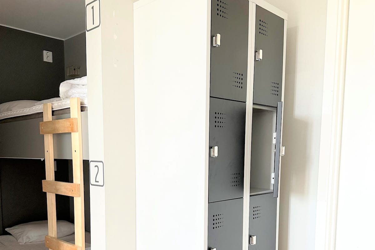 Ein Zimmer mit Stockbetten, einem Kleiderschrank und einer Leiter.
