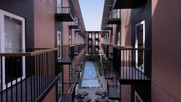 A modern building with a central courtyard, balconies, and a pool. - Amaris Hotel Pratama Nusa Dua (Nusa Dua)