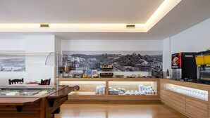 A modern kitchen with a wooden countertop, a coffee machine, and a view of a cityscape. - Stay Hotel Leiria Centro (Leiria)