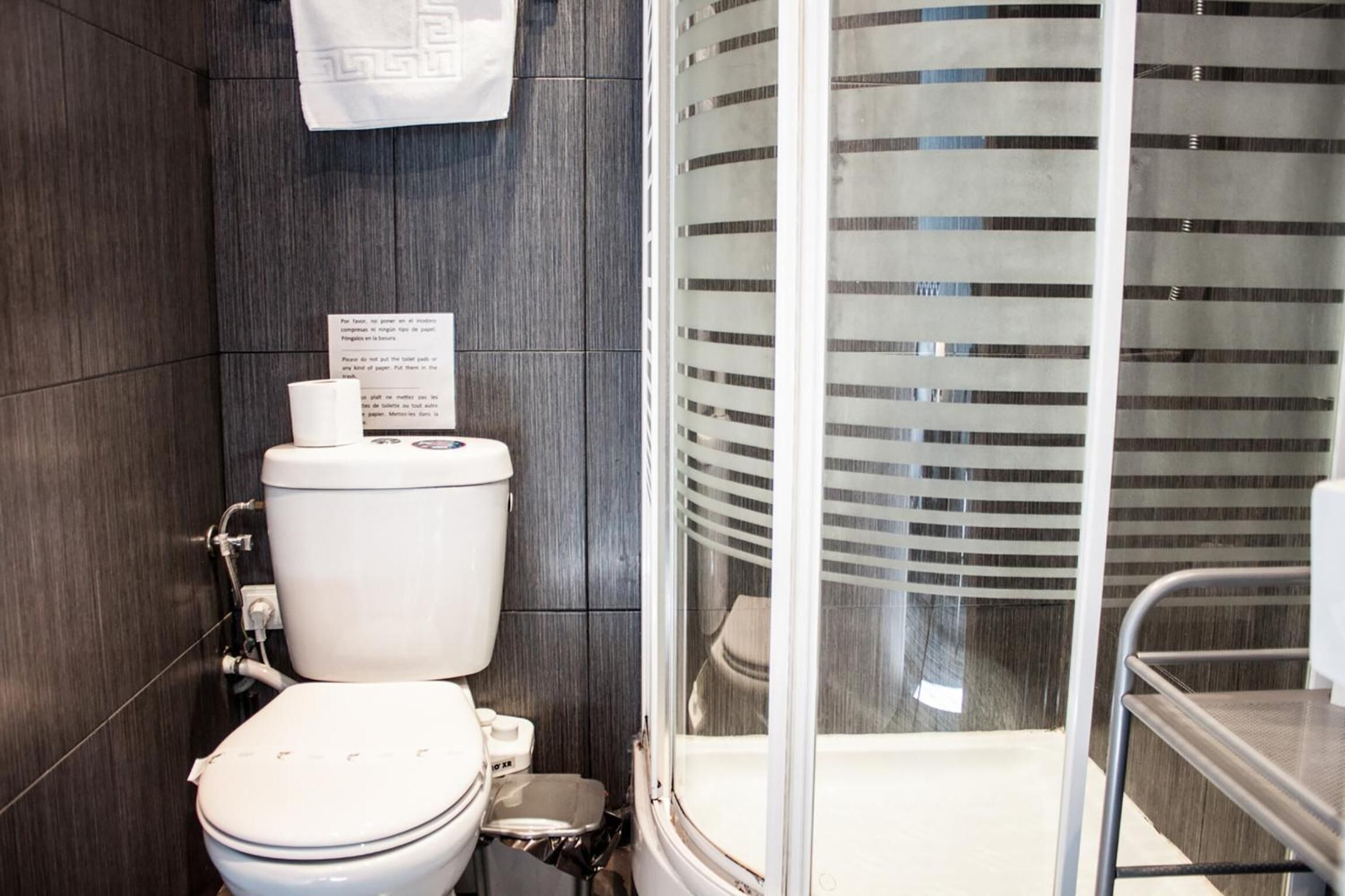 Un bagno moderno con un WC, un bidet e uno spazio doccia in vetro.
