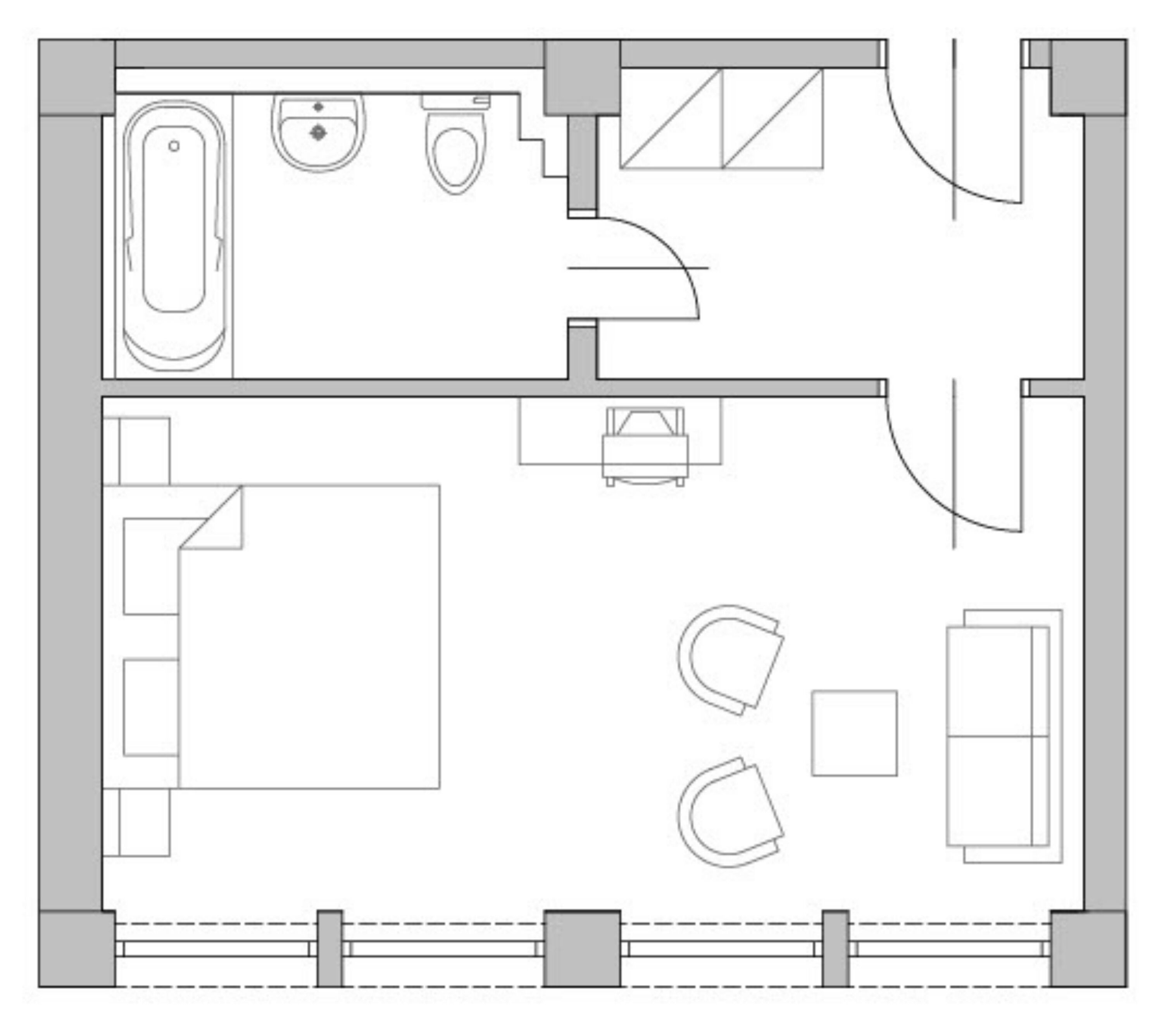 A floor plan of a hotel room with a bathroom, a small sitting area, a bed, and a desk.