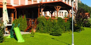 A hotel with a terrace, a playground, and a sign indicating the hotel name. - Hotel Podhradie (Povazska Bystrica)