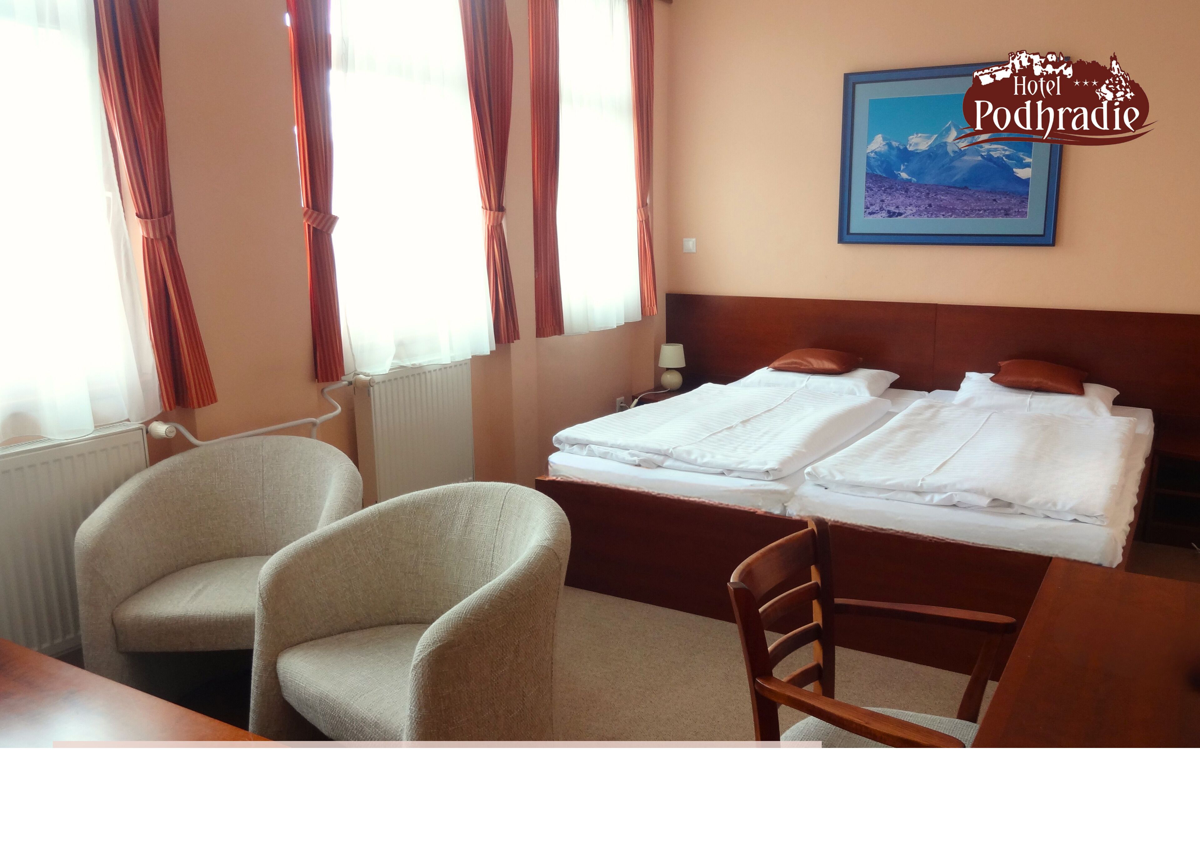 Habitación de hotel con dos camas, una silla, una mesa y un ventanal con cortinas.