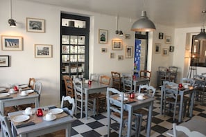 A dining area with tables set for meals, chairs, and a checkered floor. - Hôtel Saint-Michel (Dinard)