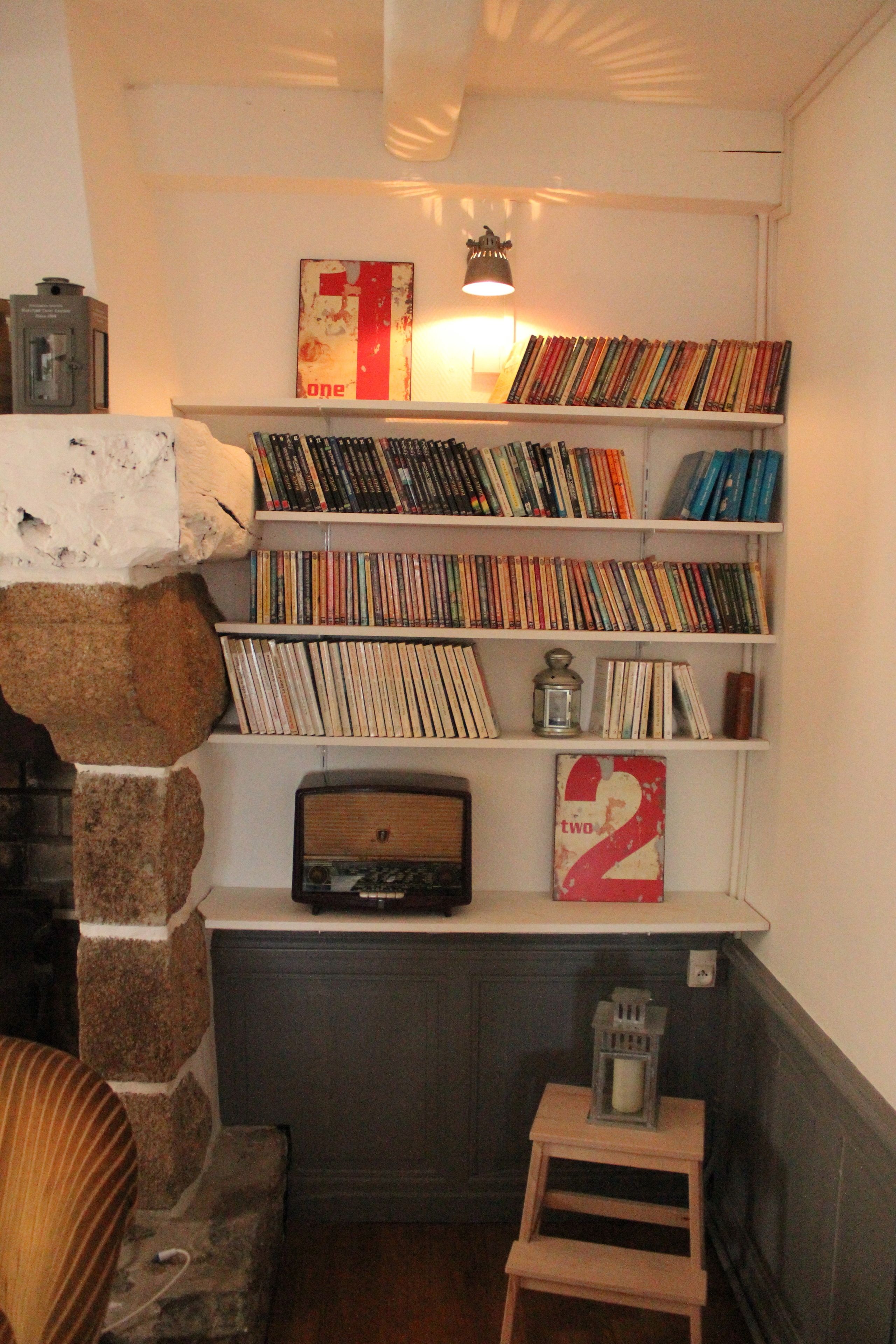 A bookshelf filled with books and a vintage radio.