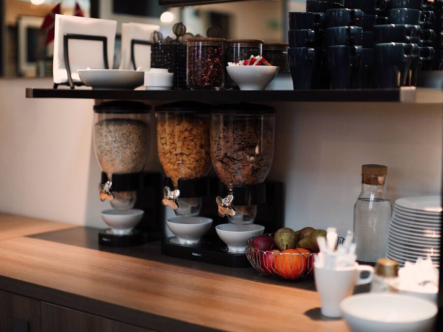 A kitchen counter with a coffee maker, two blenders, and various kitchen utensils.