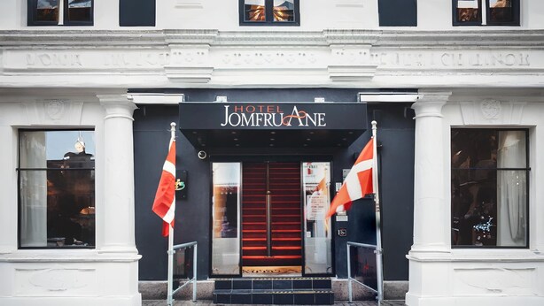 The entrance to Hotel Jomfruane with a red carpet and two flags. - Dancenter Hotel Jomfru Ane (Aalborg)