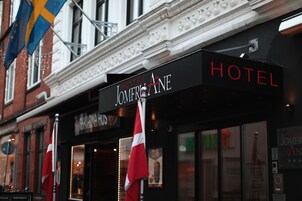 Un letrero de hotel con el nombre "HOTEL JOMFRIANE" y banderas.