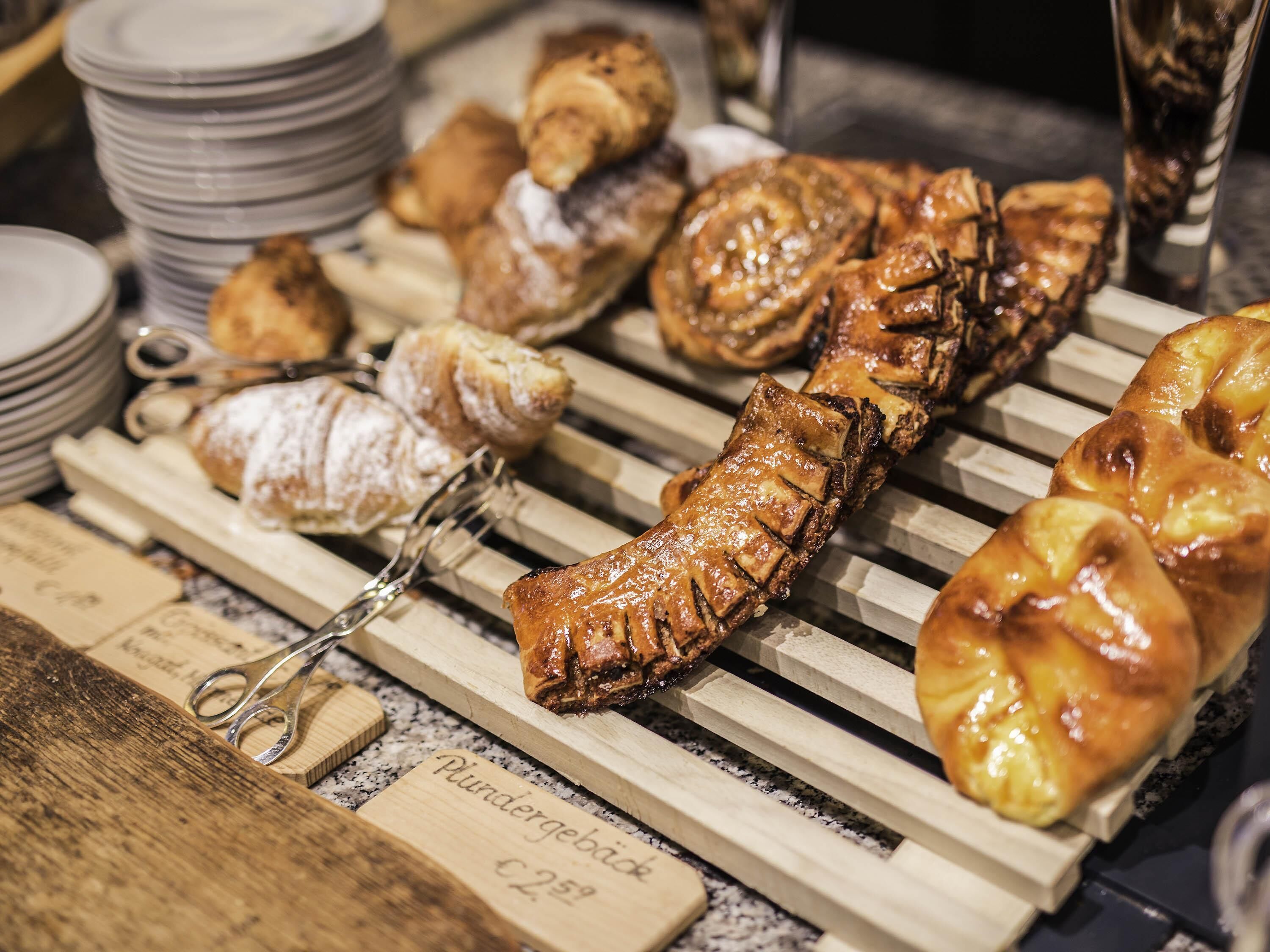 A variety of pastries displayed on wooden racks.