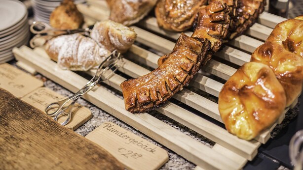 A variety of pastries displayed on wooden racks. - Hotel ibis Woerthersee (Techelsberg am Worther See)