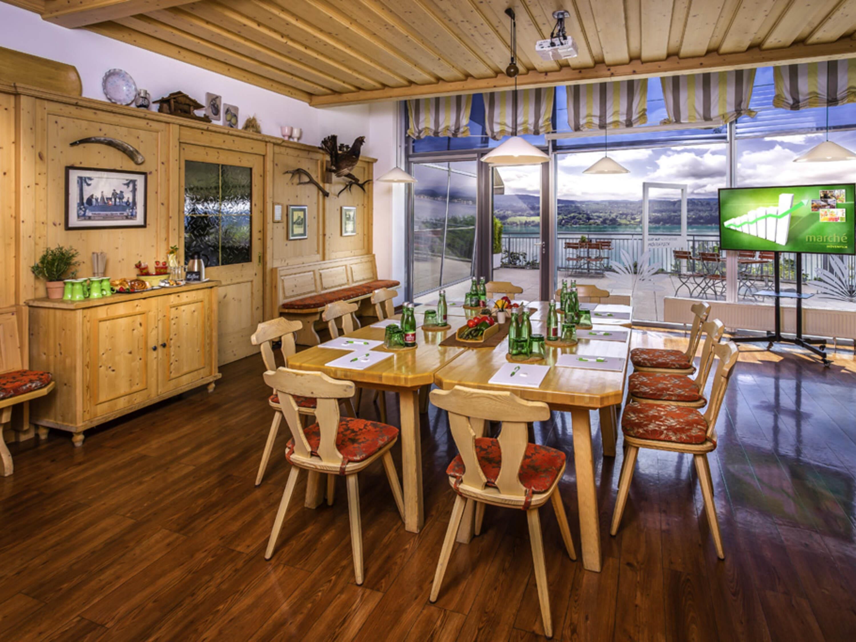 A wooden dining area with a large table, chairs, and a television.