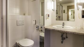 Une salle de bain moderne équipée de toilettes, d’un lavabo et d’une douche.