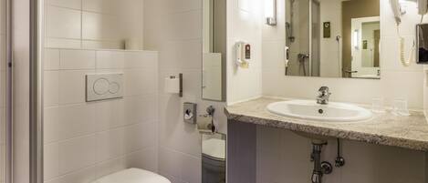 A modern bathroom with a toilet, sink, and shower.