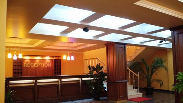 A reception area with a 'RECEPTION' sign, a staircase, and a checkered floor.