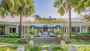 A spa with a covered entrance, stone steps, and tropical plants.