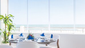 A dining table set for two with a view of the ocean.