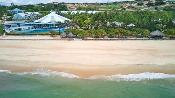 Playa privada, arena blanca, sillas reclinables de playa, sombrillas