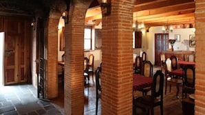 Un restaurant avec des arches en briques, un sol en pierre et des meubles en bois.