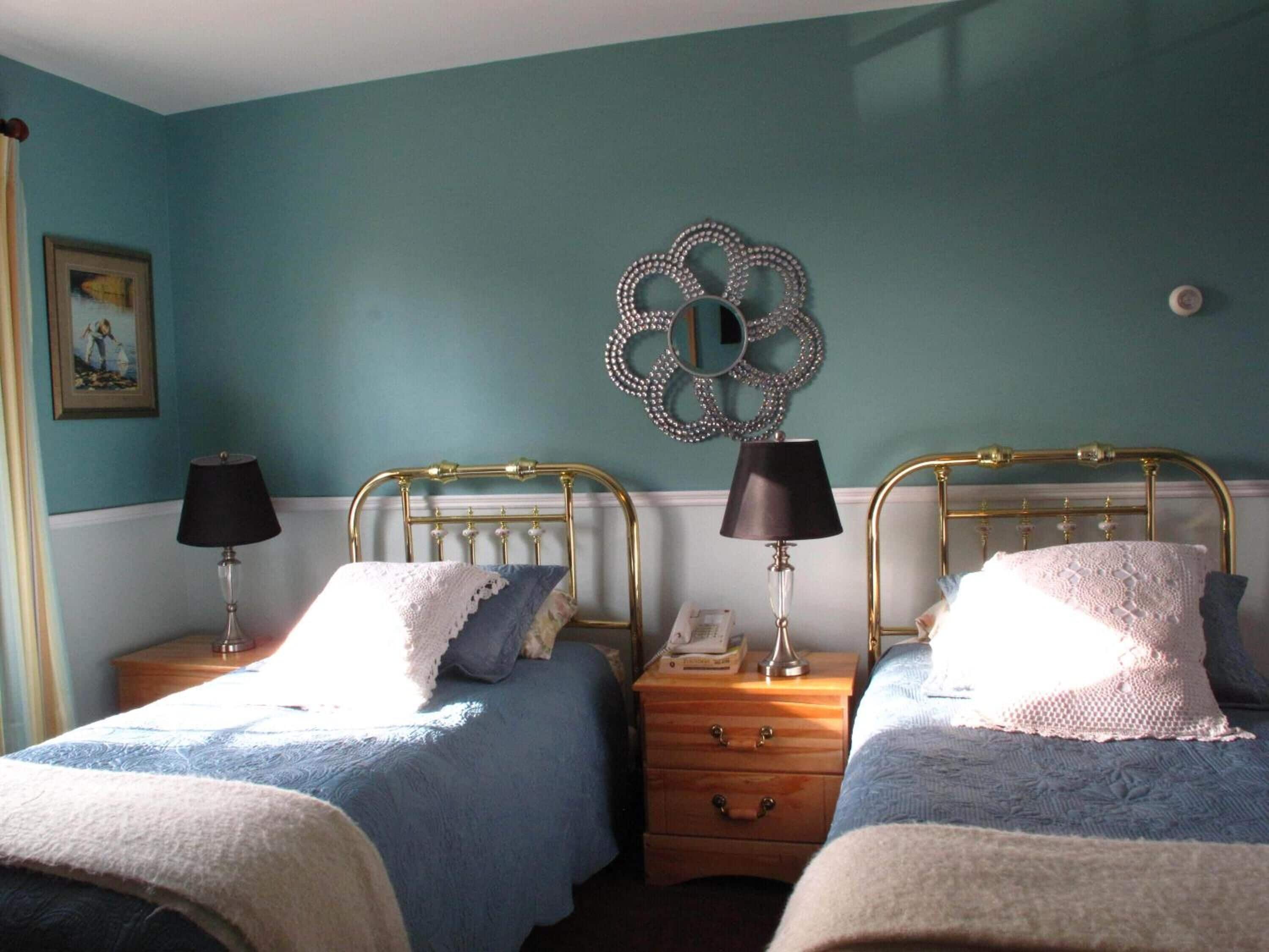 Une chambre avec deux lits, chacun étant équipé d’une lampe et d’une table de chevet.