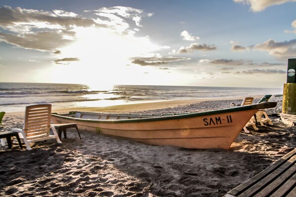 A beach scene with a boat labeled "SAM-II" and beach chairs.