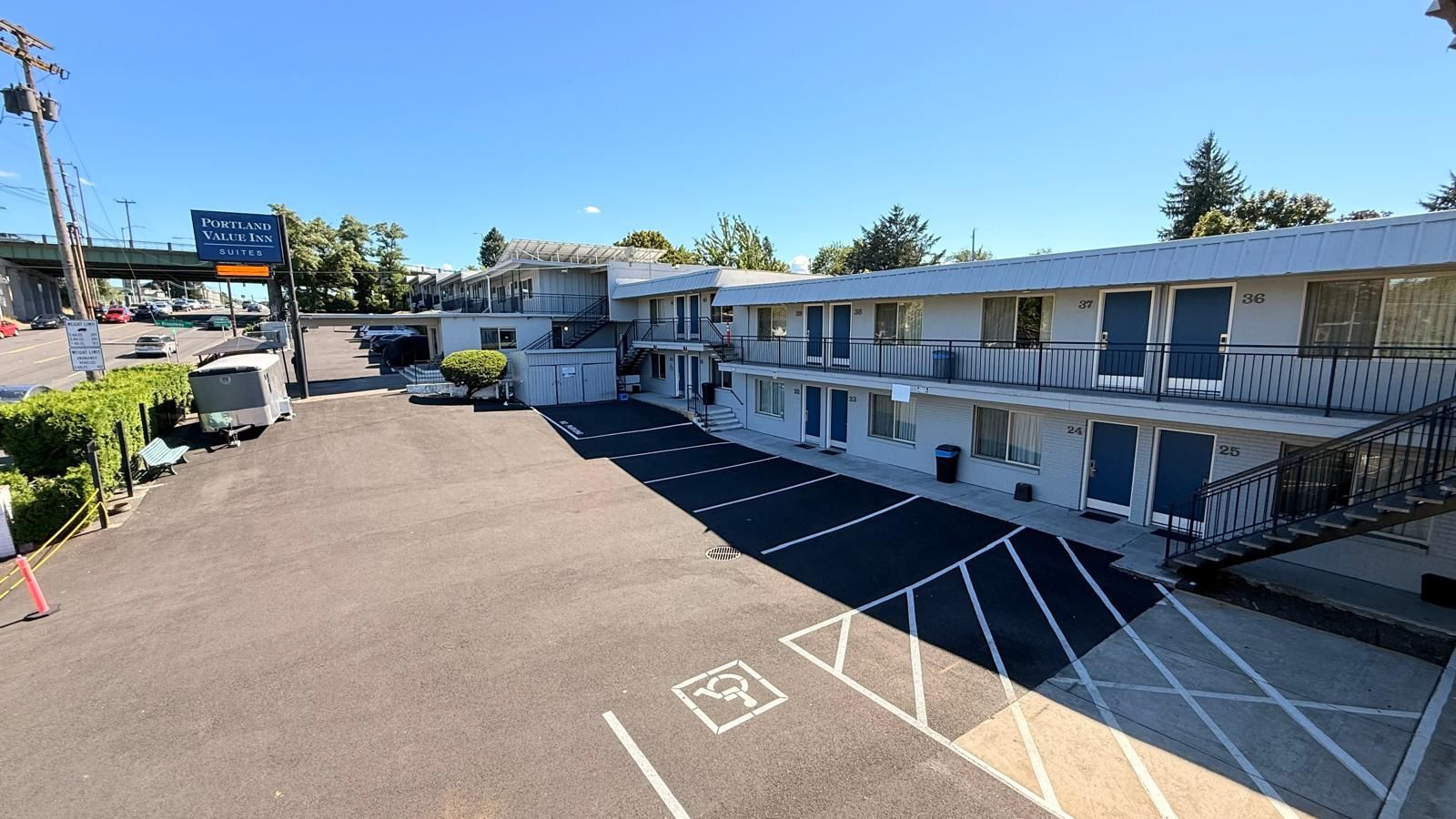 A motel with multiple units, a parking lot, and a sign for Portland Value Inn Suites.