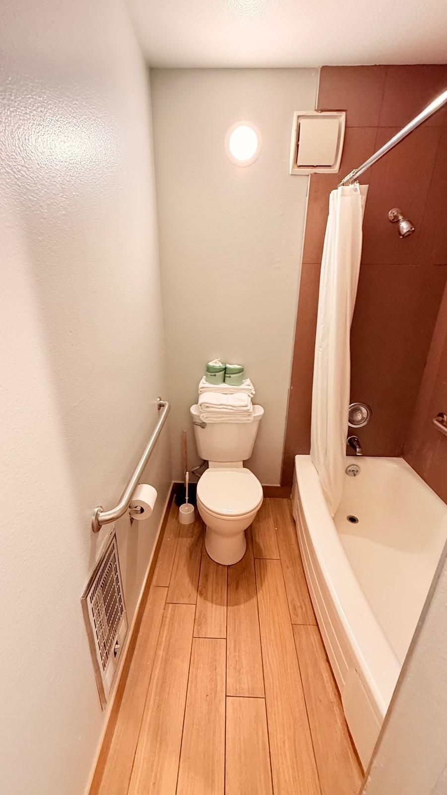 A small bathroom with a toilet, a shower, and a bathtub.