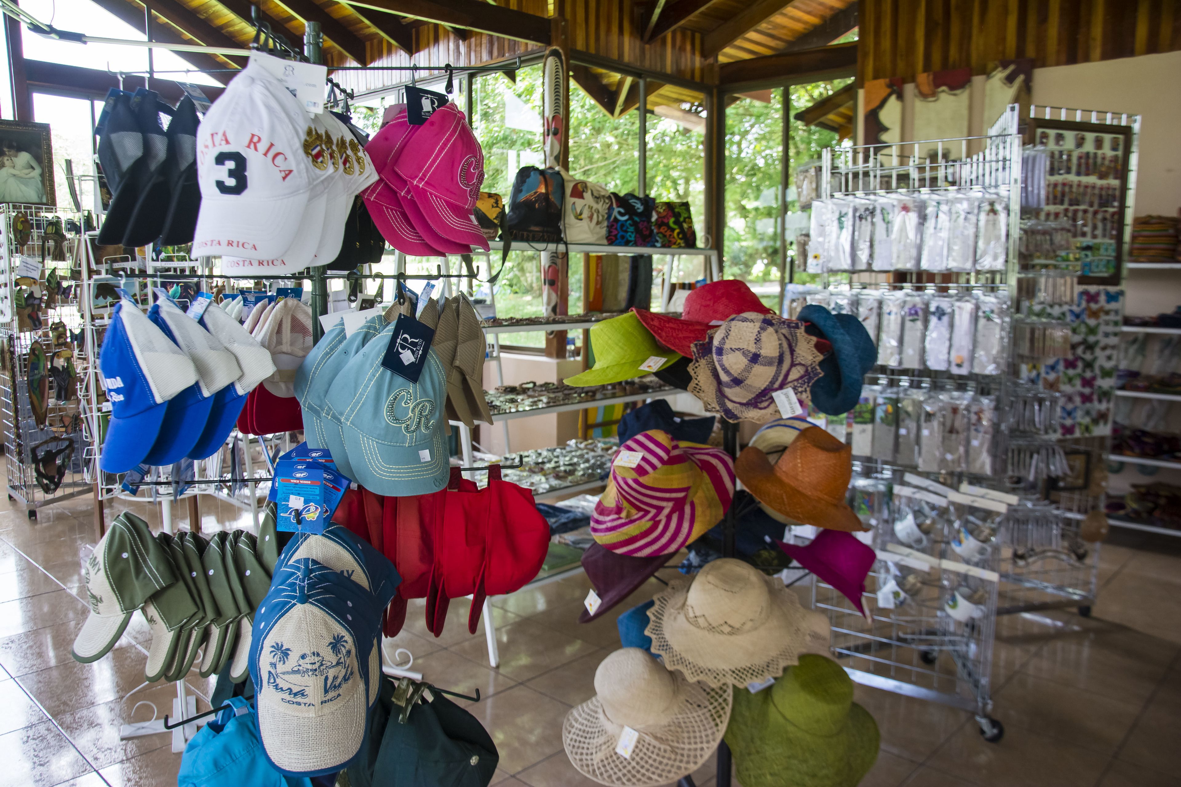 A variety of hats and bags displayed on shelves and racks in a well-lit indoor setting.