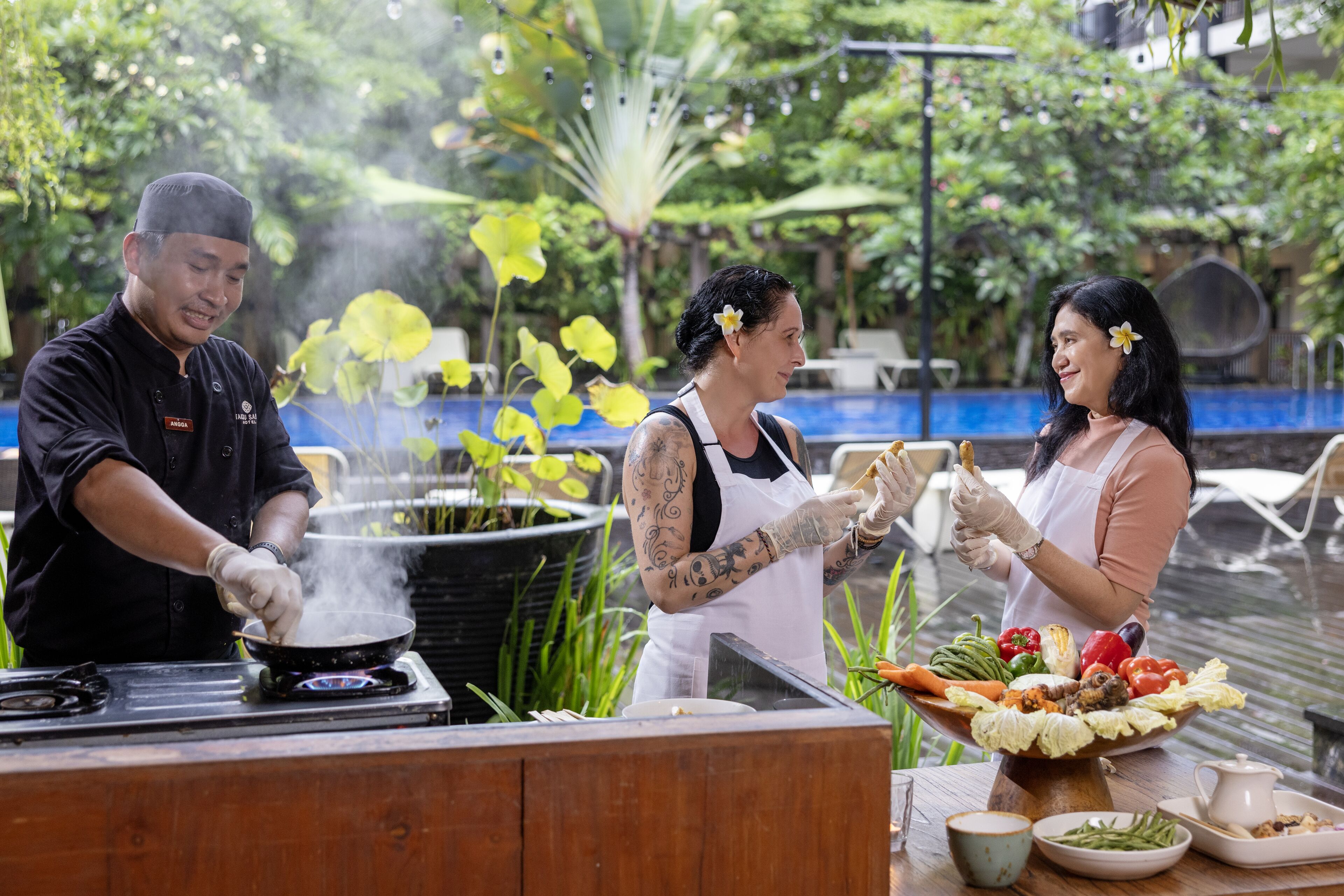 Um chef cozinha com vapor saindo da panela, cercado por vegetação exuberante e uma piscina.
