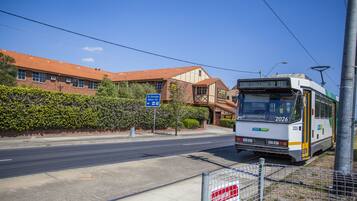 A tram at a station with a clear blue sky.