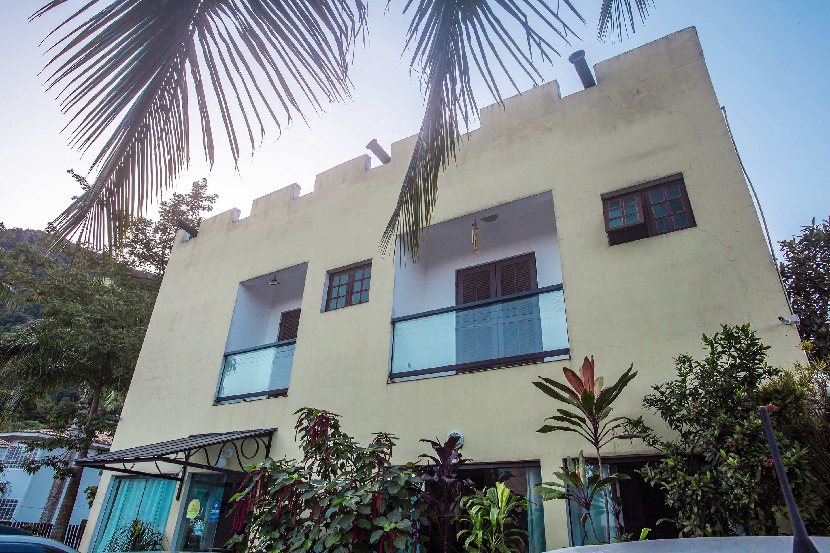 A two-story building with a flat roof and a balcony on the second floor.