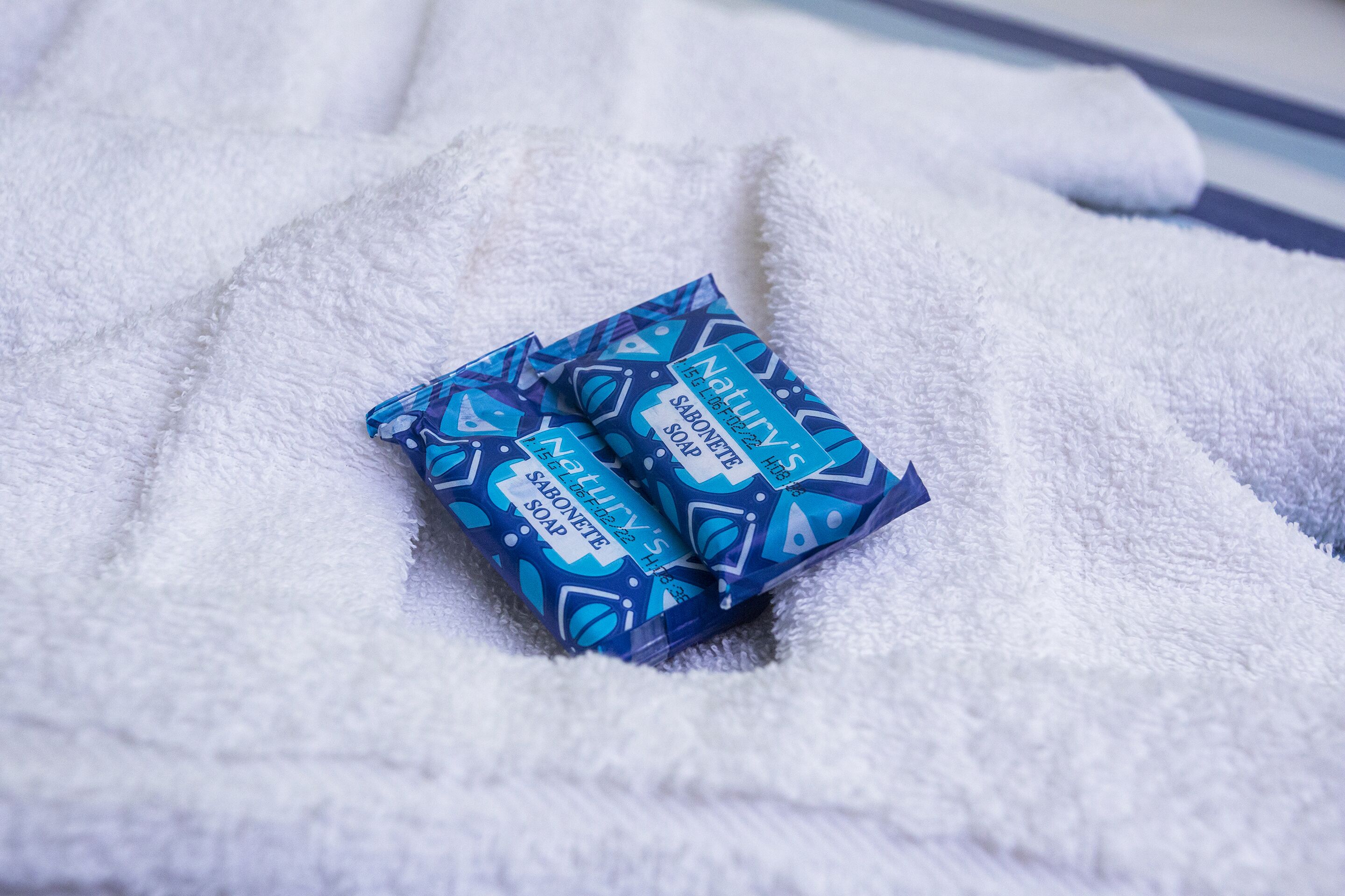 Two packages of soap on a white towel.