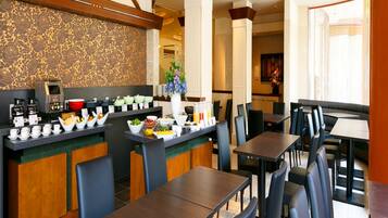 A restaurant with a buffet area, seating arrangements, and a decorative wall.