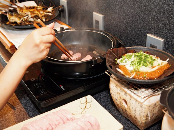 A kitchen with a stove, a pan, and a plate of food. - Hotel Resol Gifu (Gifu)