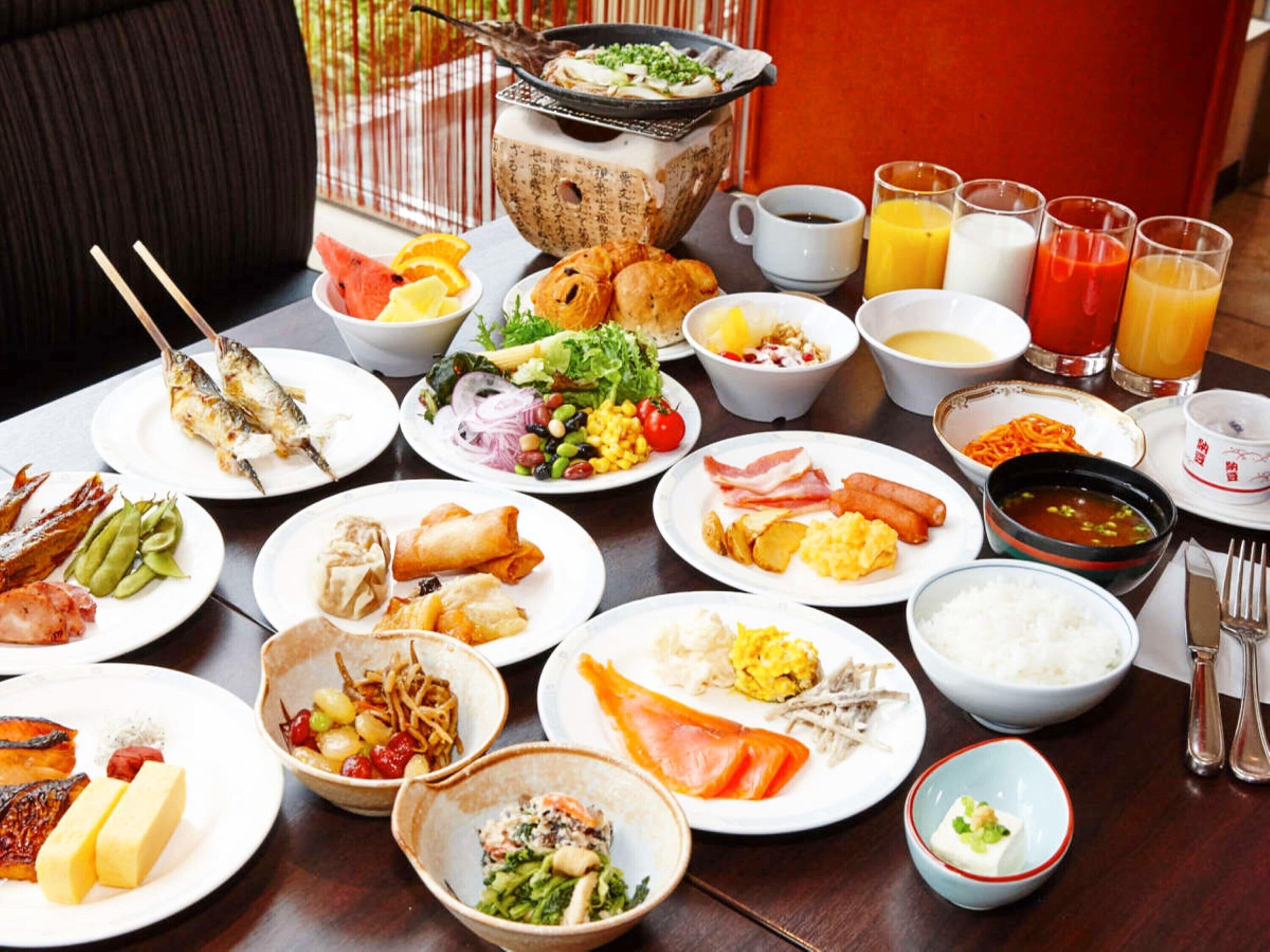 Une table où l’on trouve divers plats, notamment des sushis, des sashimis et un plat mijoté servi à table.