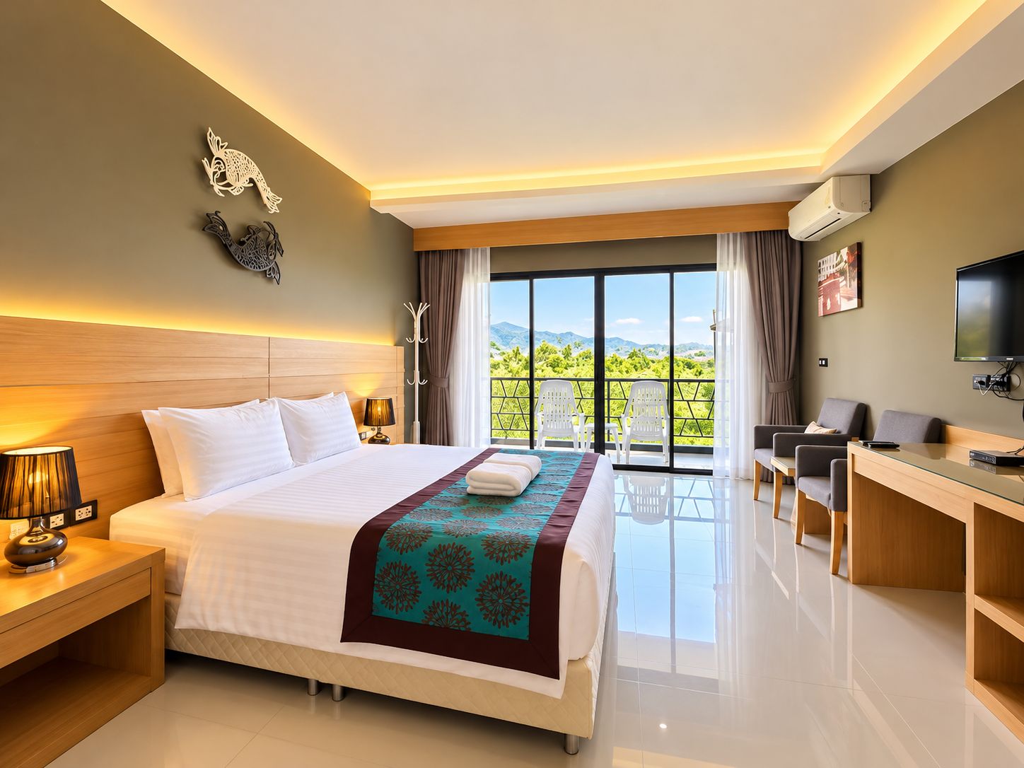 A hotel room with a large bed, a desk, a TV, and a balcony with a view of the mountains.