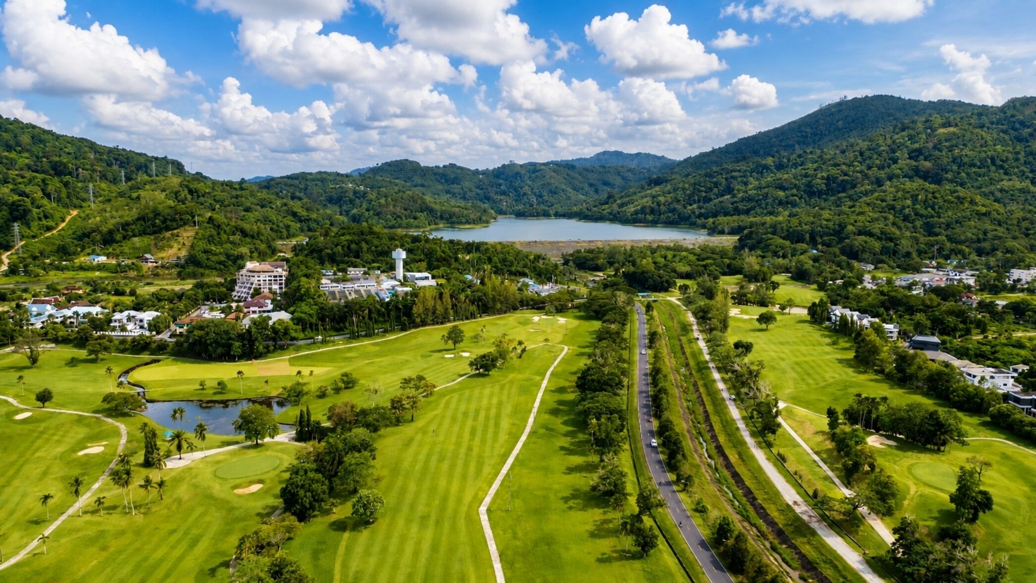 Un parcours de golf avec un lac, entouré de collines et de zones résidentielles.