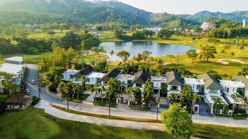 Una zona residencial con casas modernas, un campo de golf y un lago.
